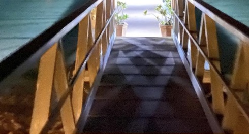 ممر خشبي مضاء بمحاذاة البحر